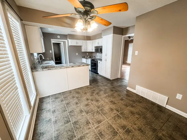 a view of a kitchen with microwave and refrigerator