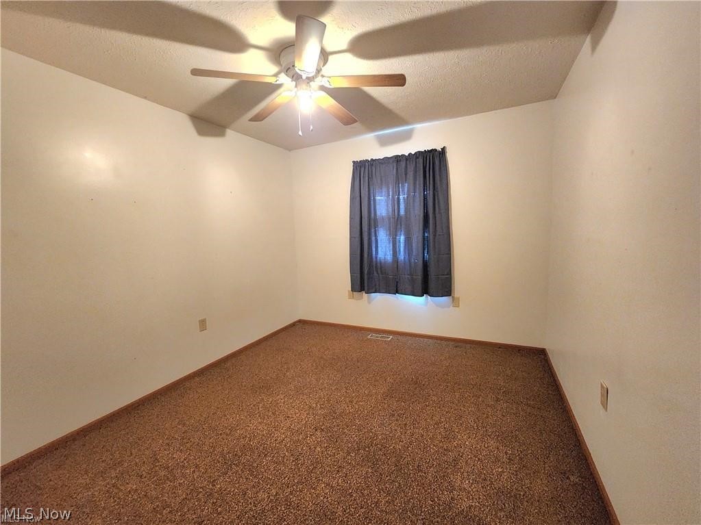 10345 Marne Road Frazeysburg, OH 43822 - Photo 30 of 50 Carpeted spare room featuring a textured ceiling and ceiling fan
