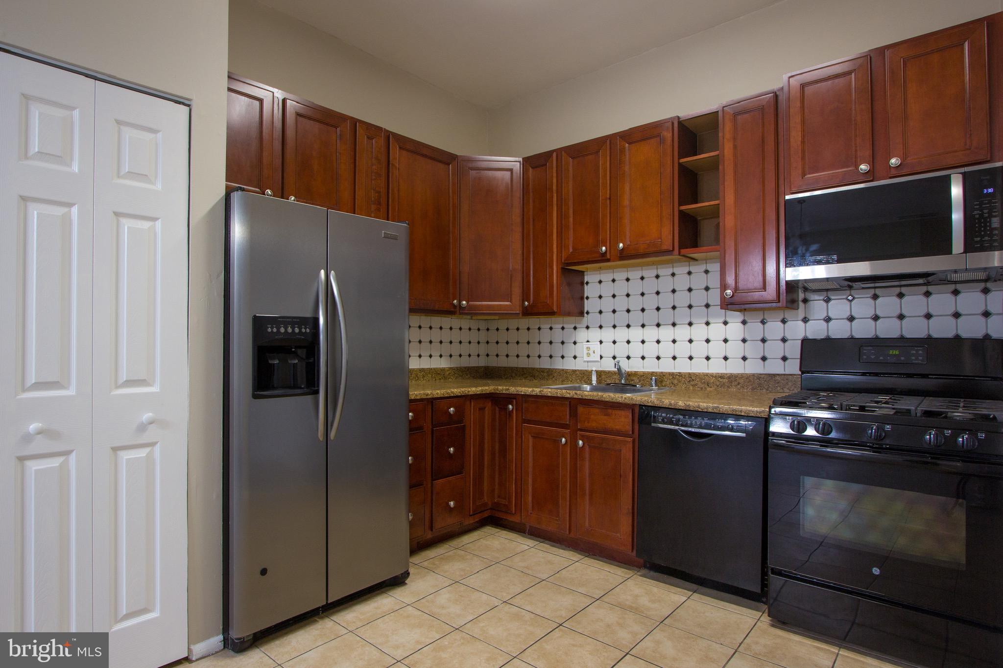 14426 Parkvale Road, Unit 5 Rockville, MD 20853 - Photo 11 of 26 a kitchen with stainless steel appliances granite countertop a refrigerator stove and microwave