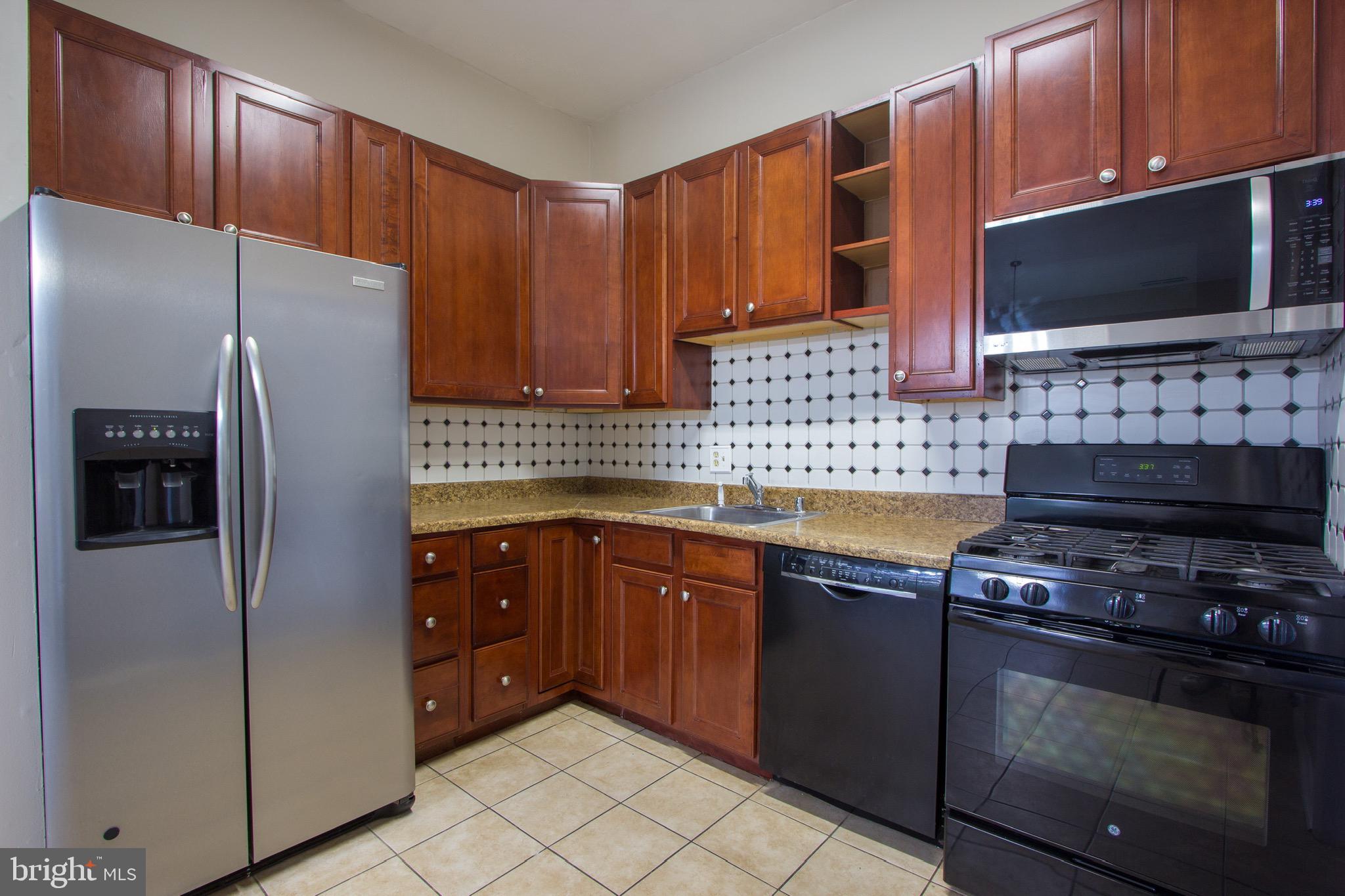 14426 Parkvale Road, Unit 5 Rockville, MD 20853 - Photo 12 of 26 a kitchen with stainless steel appliances granite countertop a refrigerator stove and microwave