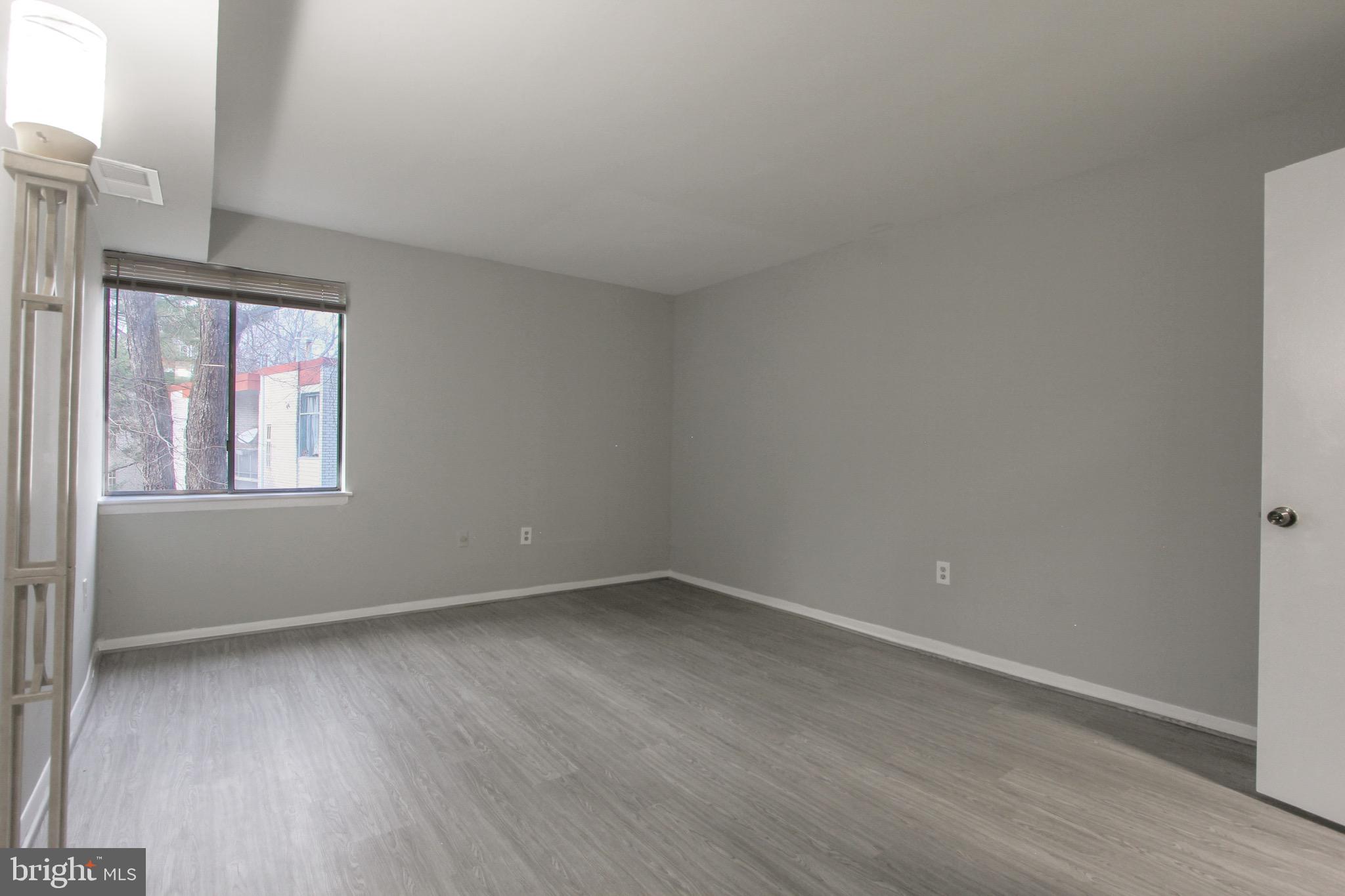 14426 Parkvale Road, Unit 5 Rockville, MD 20853 - Photo 17 of 26 an empty room with wooden floor and windows