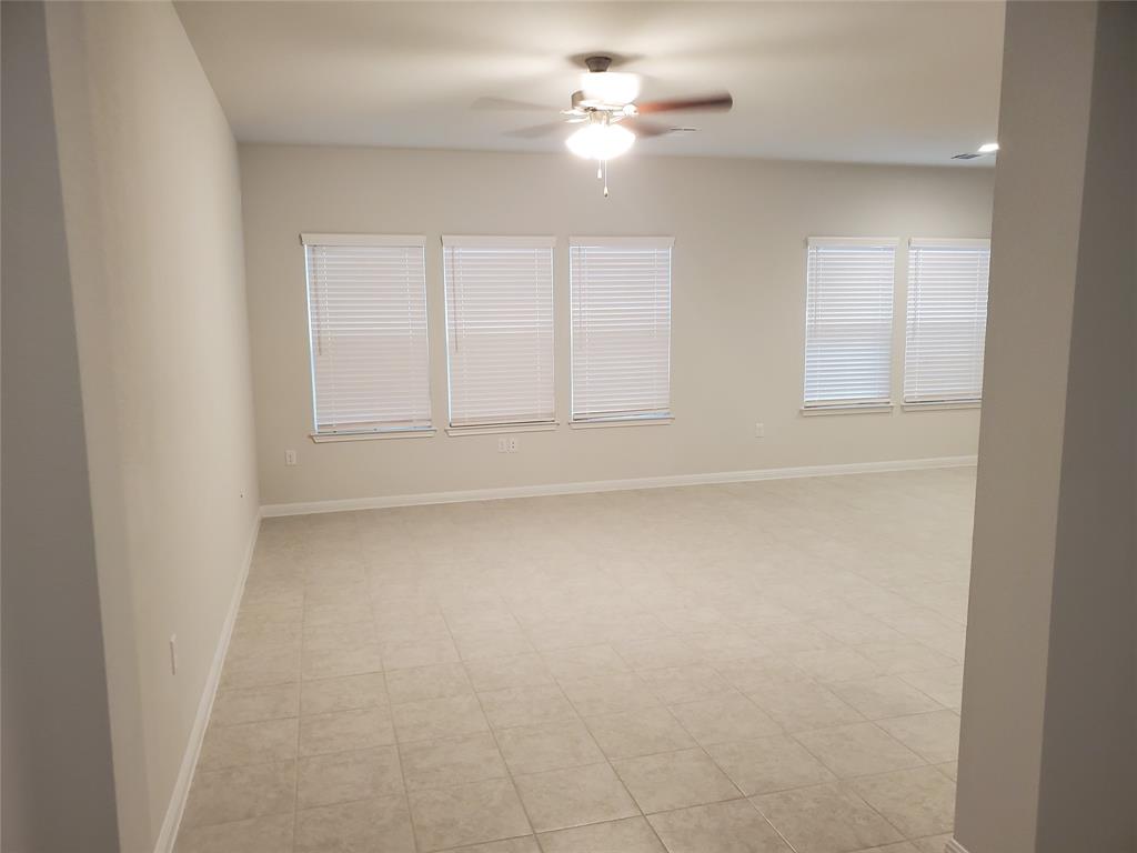 6404 Gunflint Drive Austin, TX 78747 - Photo 12 of 21 A spacious, naturally illuminated room features elegant tiled flooring and multiple large windows.