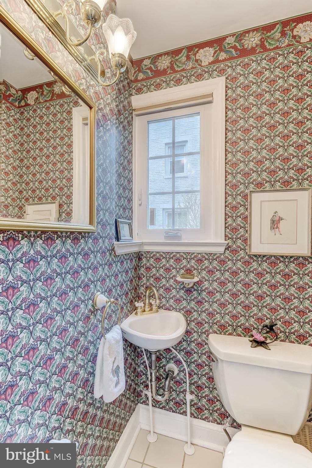 5704 Kenmore Road Baltimore, MD 21210 - Photo 12 of 30 a bathroom with a toilet a sink and a window