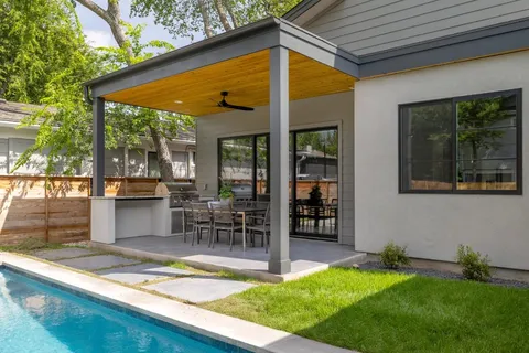a view of a house with backyard and sitting area