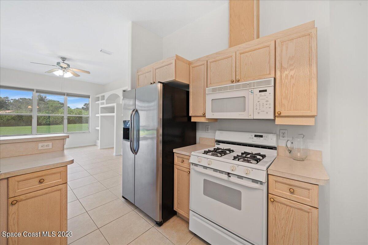 853 Villa Drive Melbourne, FL 32940 - Photo 13 of 28 a kitchen with white cabinets and white appliances