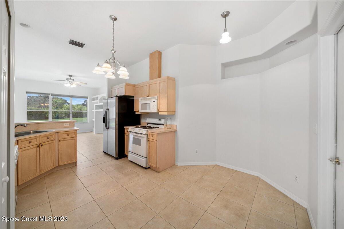 853 Villa Drive Melbourne, FL 32940 - Photo 14 of 28 a large kitchen with cabinets and stainless steel appliances
