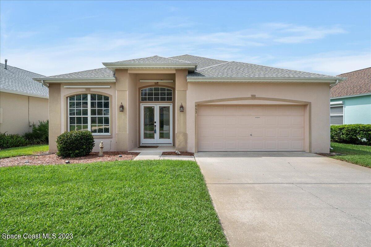853 Villa Drive Melbourne, FL 32940 - Photo 3 of 28 a front view of a house with a yard and garage