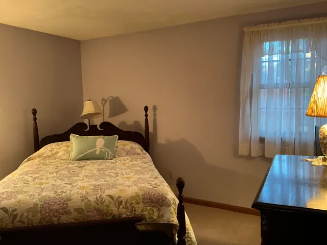 a bed sitting in a bedroom next to a window