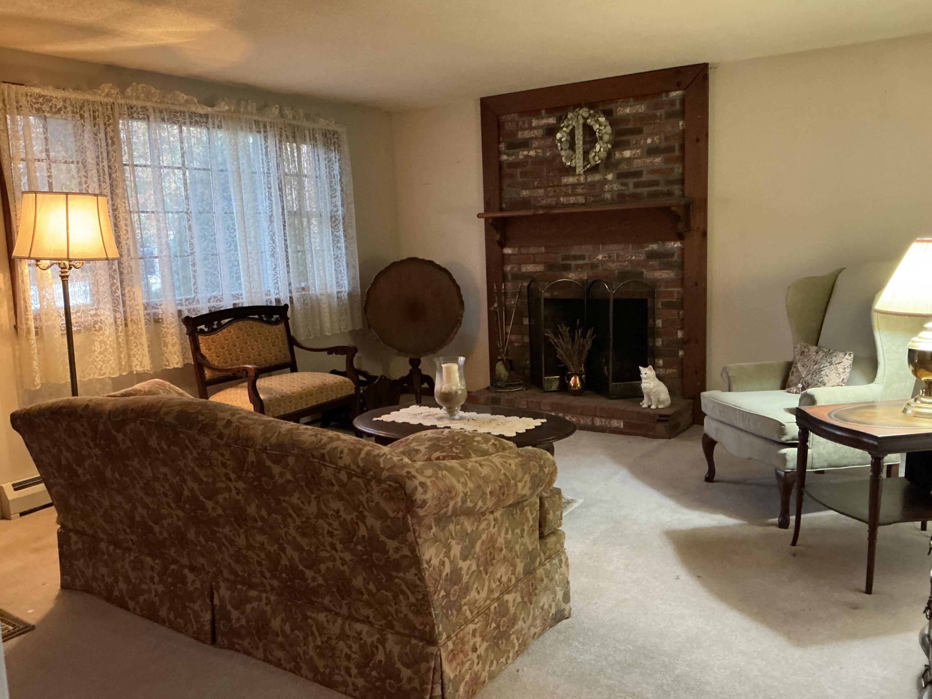 29 Windshore Drive Hyannis, MA 02601 - Photo 4 of 32 a living room with furniture a lamp and a fireplace