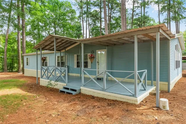 a view of backyard with a barn and a large tree