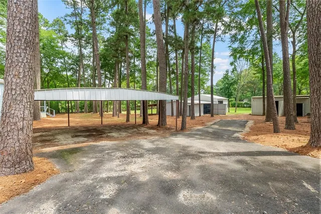 a view of a house with backyard and trees