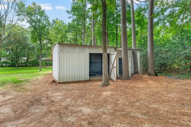 a view of a house with backyard and trees