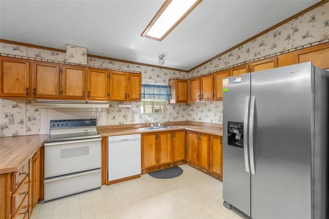 a kitchen with stainless steel appliances granite countertop a refrigerator sink and cabinets