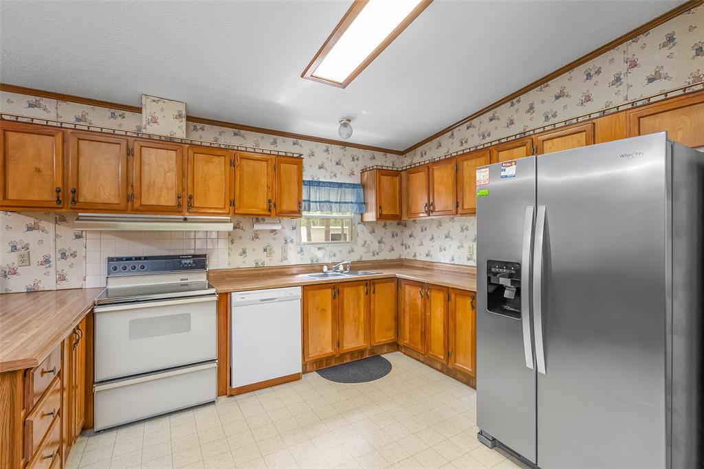 121 Woolworth Road Stonewall, LA 71078 - Photo 10 of 32 a kitchen with stainless steel appliances granite countertop a refrigerator sink and cabinets
