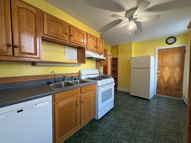 a kitchen with stainless steel appliances granite countertop a sink and a refrigerator