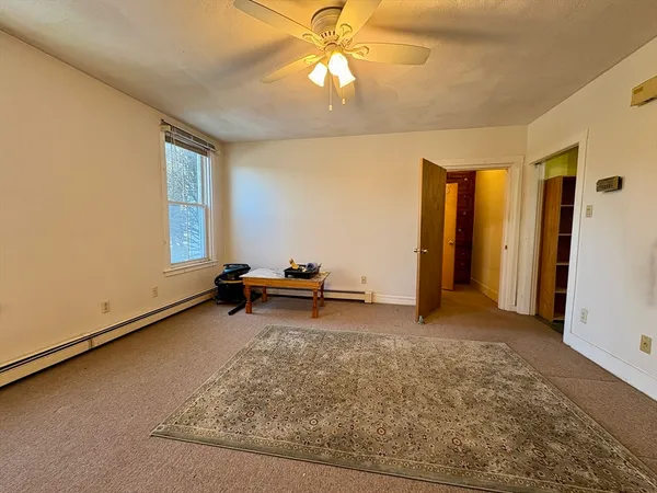 an empty room with windows and ceiling fan