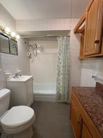 a bathroom with a granite countertop toilet sink and mirror