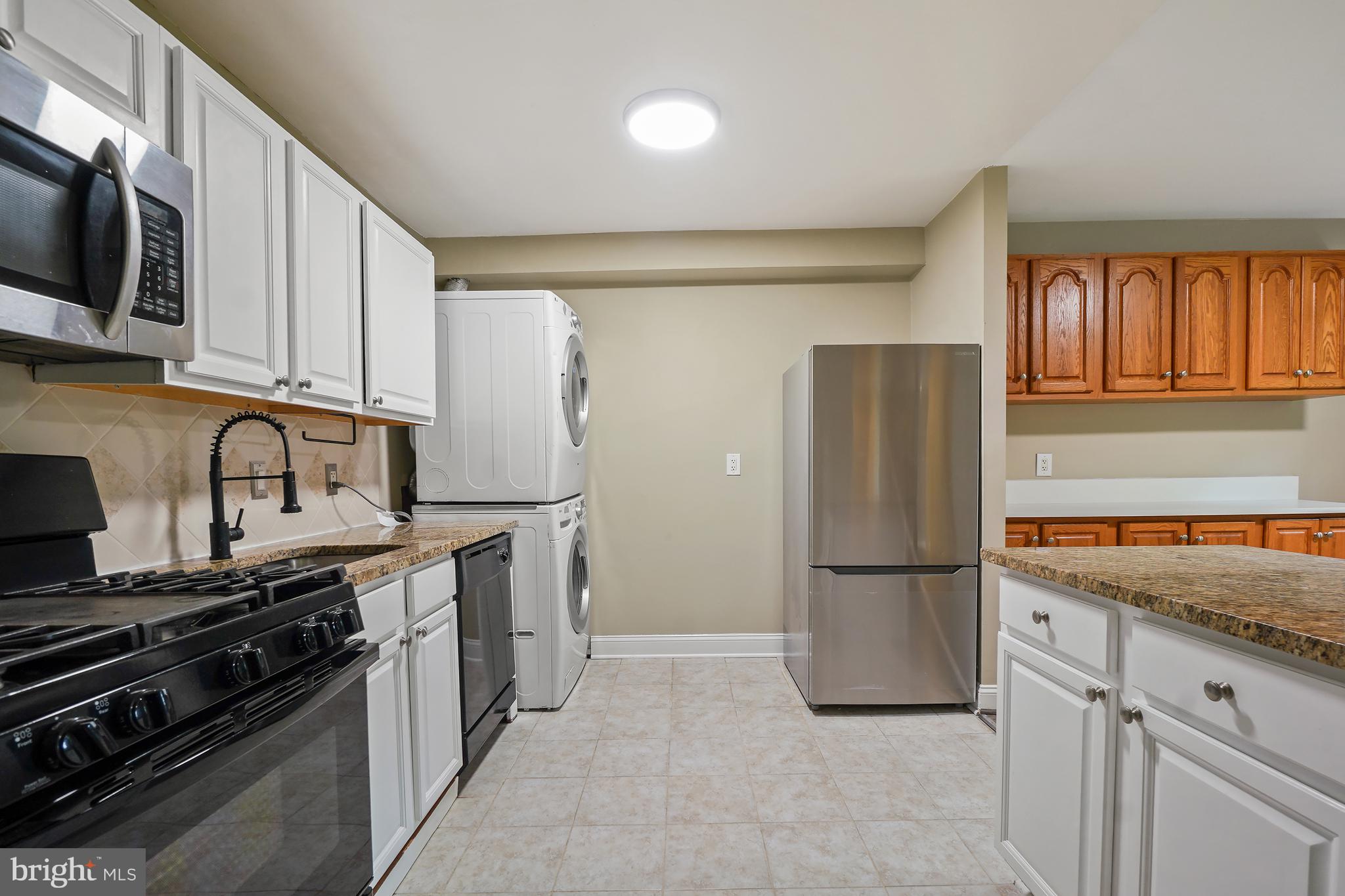 8487 Greenbelt Road Greenbelt, MD 20770 - Photo 10 of 29 a kitchen with stainless steel appliances granite countertop a refrigerator and a stove top oven