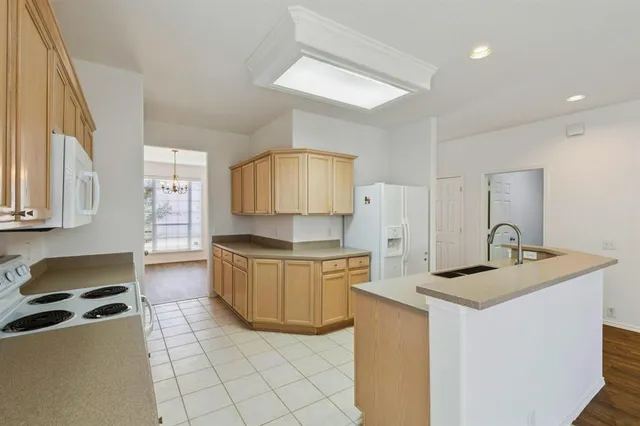 a kitchen with granite countertop a sink a stove top oven and cabinets