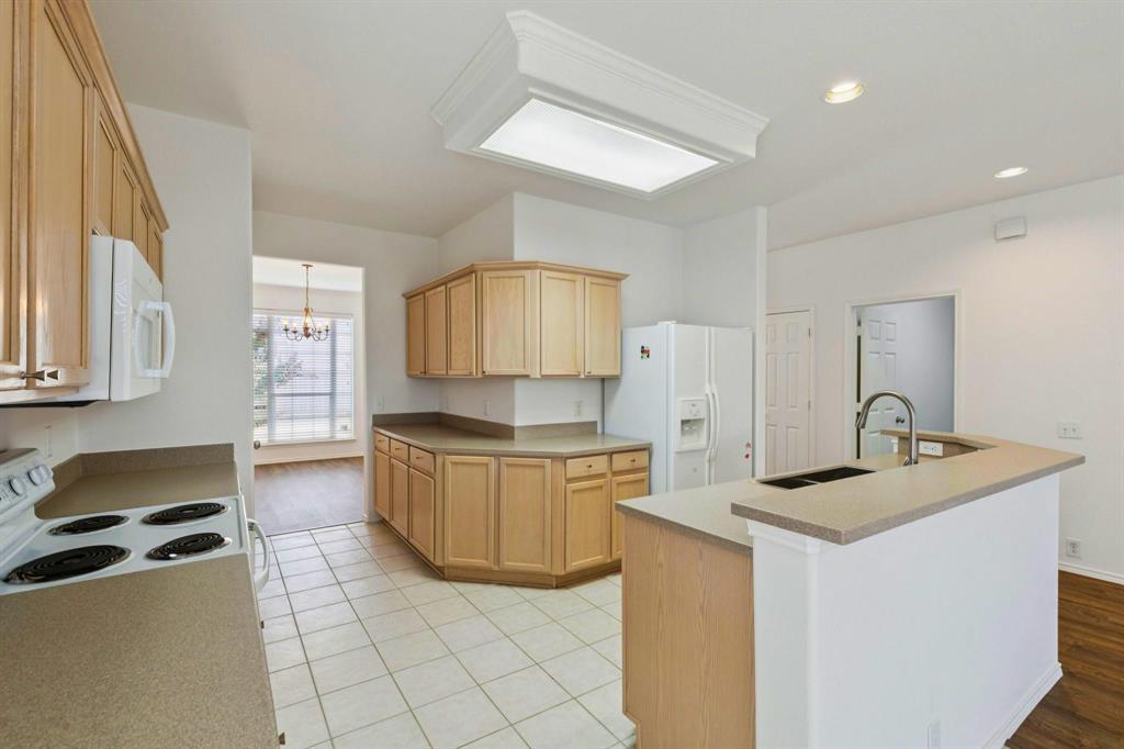6439 Chester Drive Frisco, TX 75035 - Photo 6 of 12 a kitchen with granite countertop a sink a stove top oven and cabinets