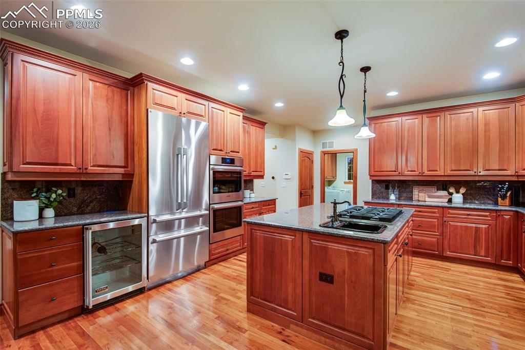 16075 Winding Trail Road Colorado Springs, CO 80908 - Photo 15 of 42 a kitchen with stainless steel appliances kitchen island granite countertop a stove refrigerator and cabinets