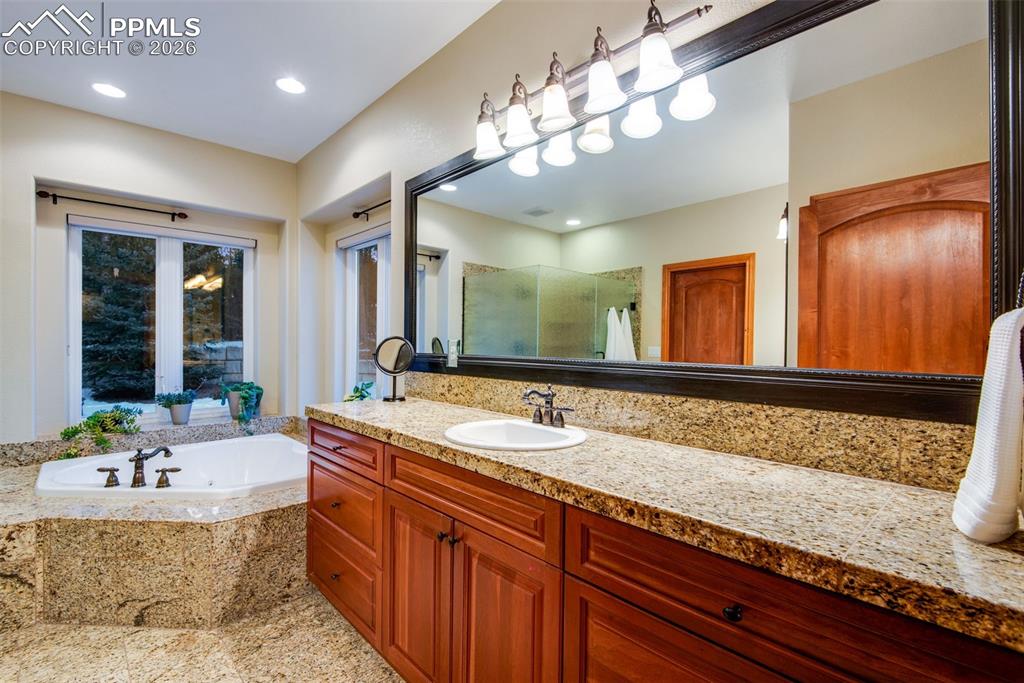 16075 Winding Trail Road Colorado Springs, CO 80908 - Photo 22 of 42 a bathroom with a tub sink and mirror