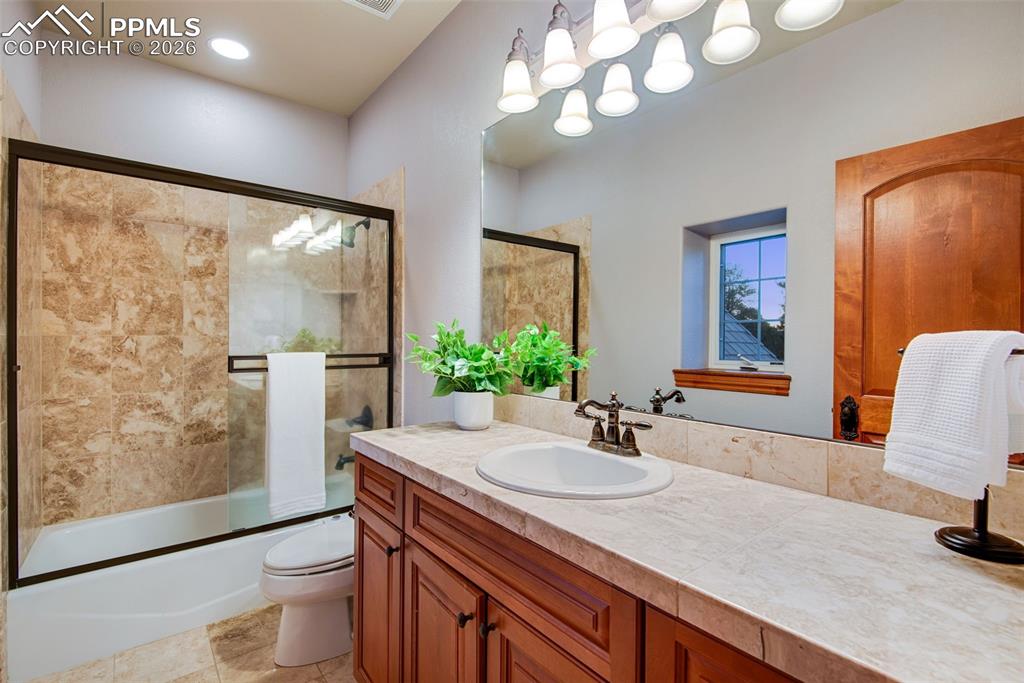 16075 Winding Trail Road Colorado Springs, CO 80908 - Photo 26 of 42 a bathroom with a sink a toilet and a large mirror