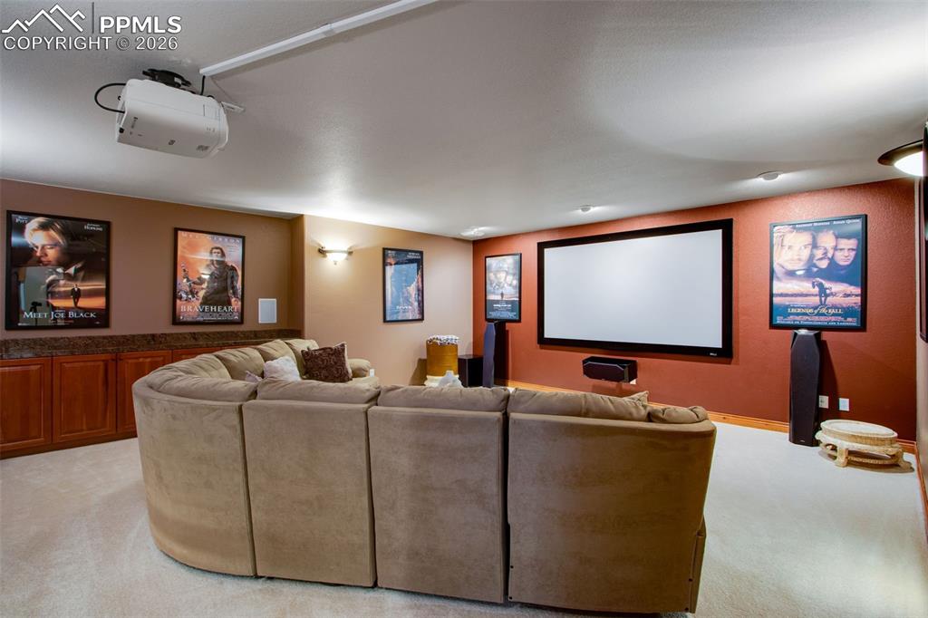16075 Winding Trail Road Colorado Springs, CO 80908 - Photo 30 of 42 a living room with furniture projector and screen