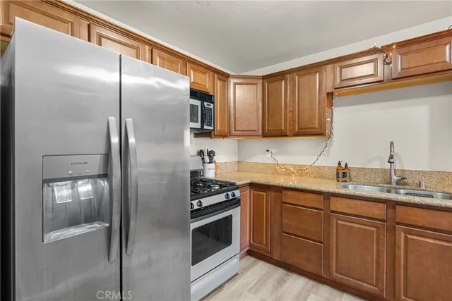 a kitchen with stainless steel appliances granite countertop a refrigerator and a sink