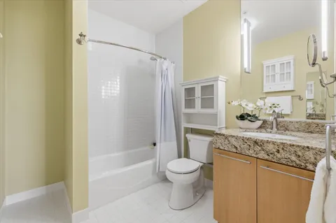 a bathroom with a granite countertop sink a toilet and shower