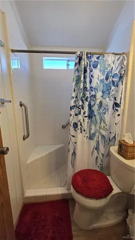 a bathroom with a toilet and a shower