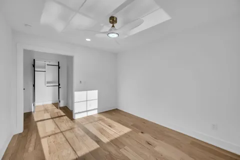 a view of empty room with wooden floor