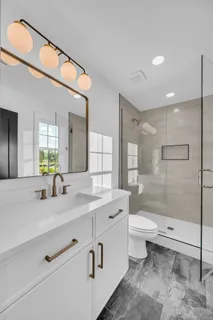 a bathroom with a granite countertop sink mirror toilet and bathtub