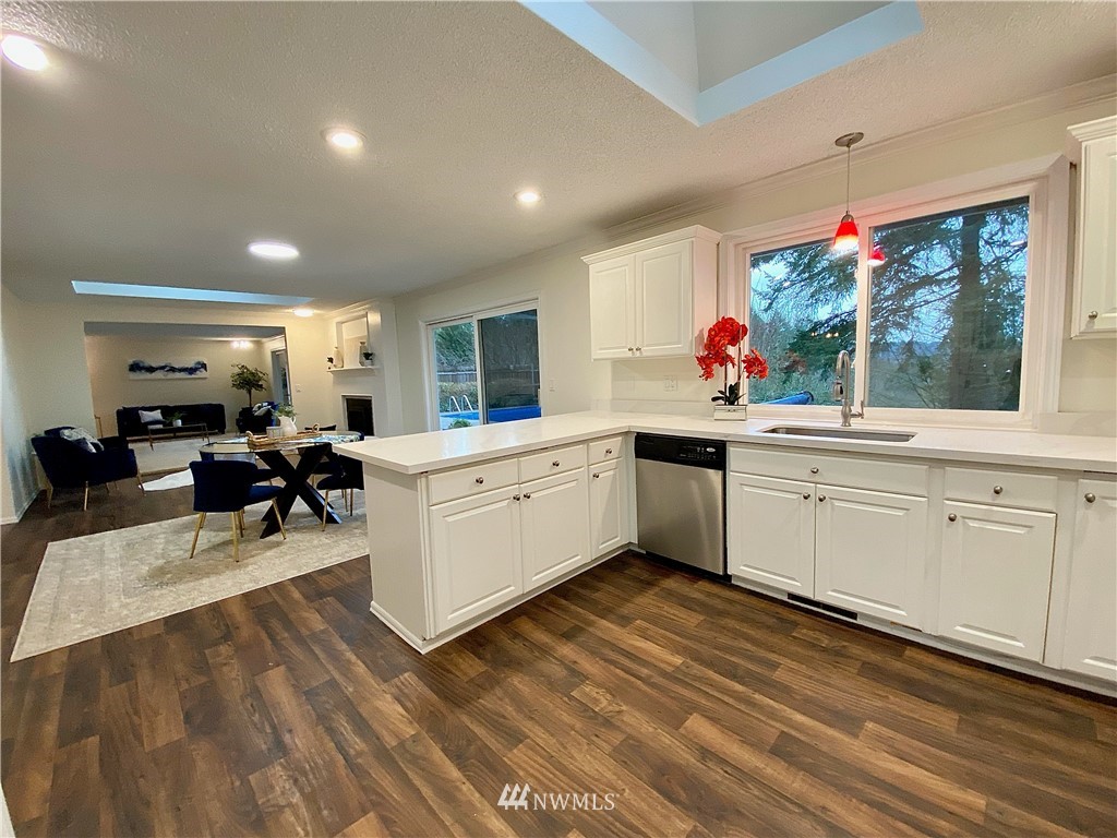 14902 175th Avenue Southeast Renton, WA 98059 - Photo 11 of 39 a kitchen that has a lot of white cabinets a sink and wooden floor