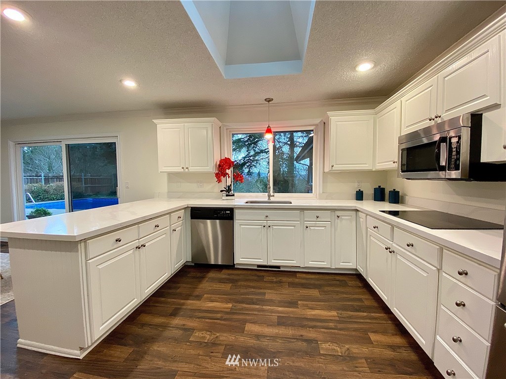14902 175th Avenue Southeast Renton, WA 98059 - Photo 13 of 39 a kitchen with stainless steel appliances granite countertop a sink and cabinets