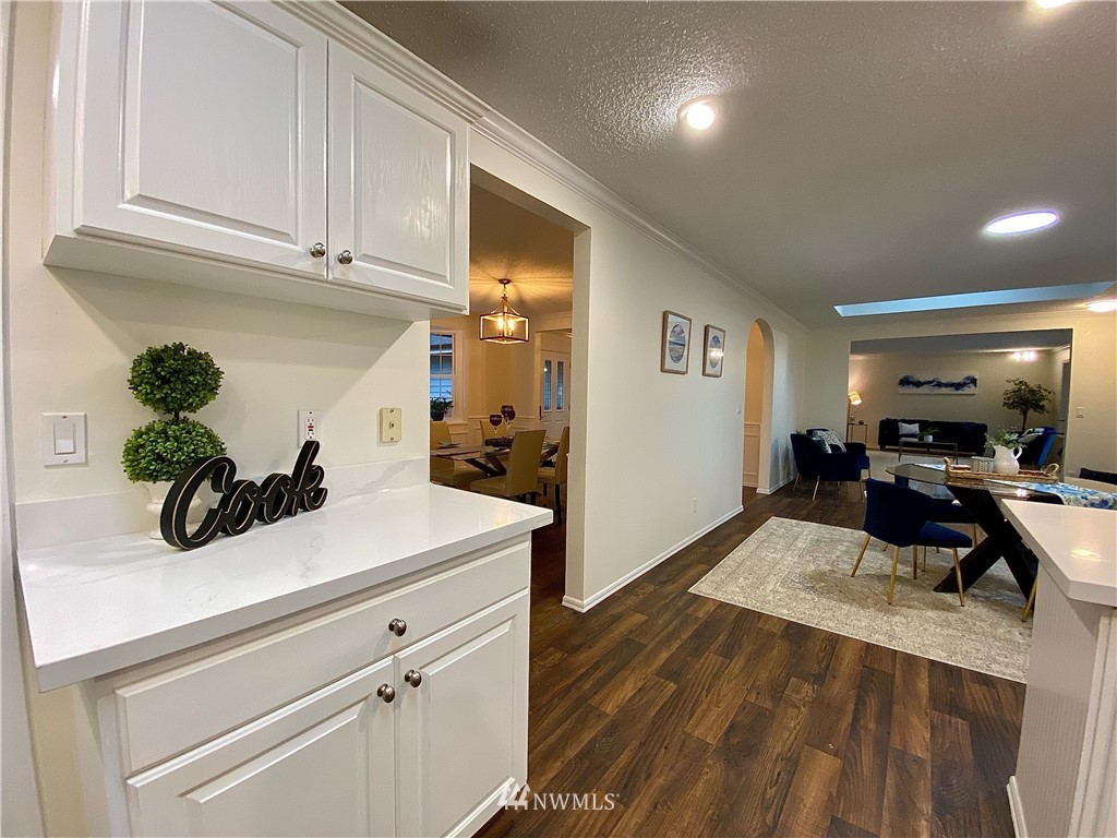 14902 175th Avenue Southeast Renton, WA 98059 - Photo 14 of 39 a view of a kitchen with kitchen island a counter top space a sink wooden floor and living room view