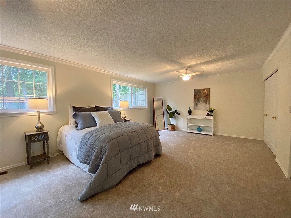 14902 175th Avenue Southeast Renton, WA 98059 - Photo 16 of 39 a spacious bedroom with a bed a table and windows