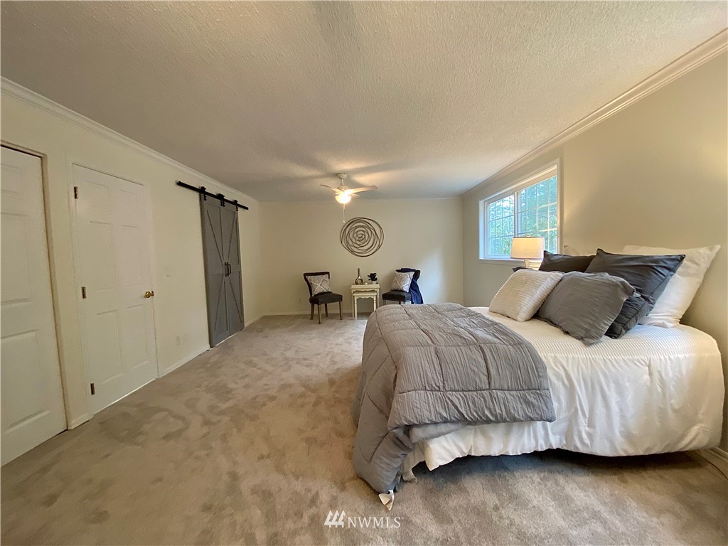 14902 175th Avenue Southeast Renton, WA 98059 - Photo 18 of 39 a bedroom with a bed and wooden floor