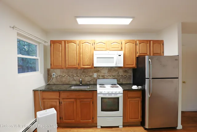 a kitchen with granite countertop a refrigerator and a stove top oven