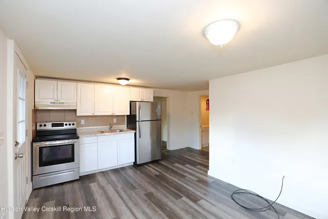 a kitchen with a refrigerator and a stove top oven