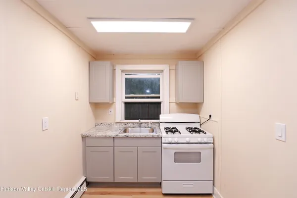 a kitchen with a stove cabinets and a window