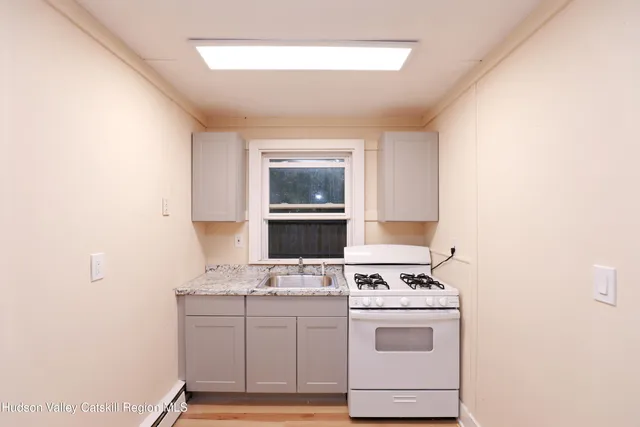 a kitchen with a stove cabinets and a window