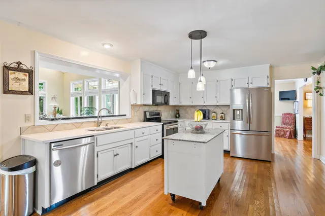 a kitchen with white cabinets stainless steel appliances and kitchen island