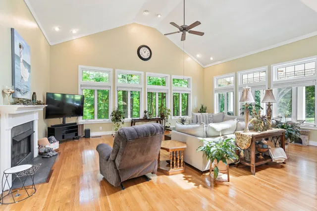 a living room with furniture fireplace and a large window