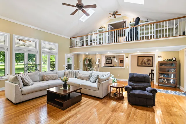 a living room with furniture ceiling fan and a window