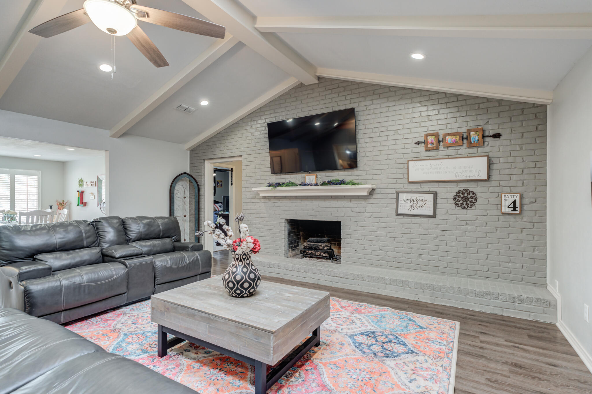 3410 76th Street Lubbock, TX 79423 - Photo 14 of 38 a living room with furniture a flat screen tv and a fireplace