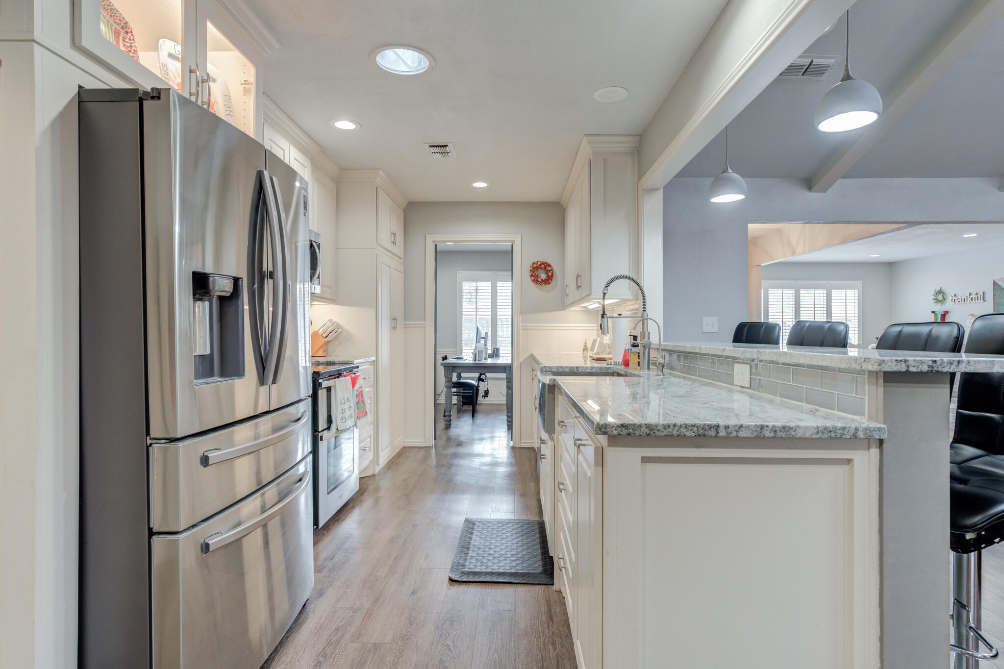 3410 76th Street Lubbock, TX 79423 - Photo 18 of 38 a kitchen with granite countertop a refrigerator and a sink