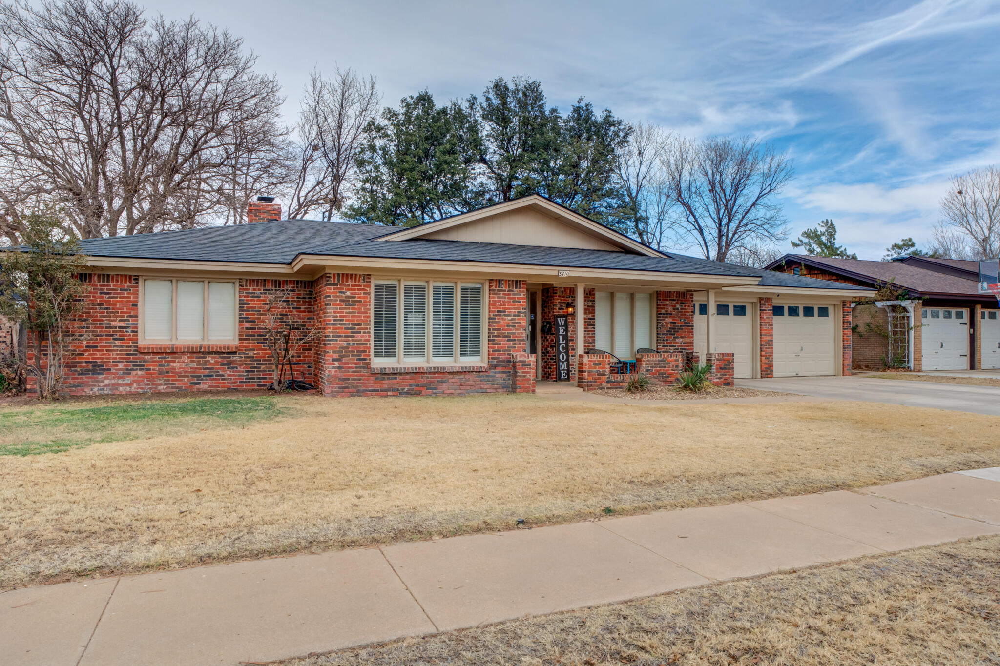 3410 76th Street Lubbock, TX 79423 - Photo 2 of 38 a front view of a house with a yard and garage