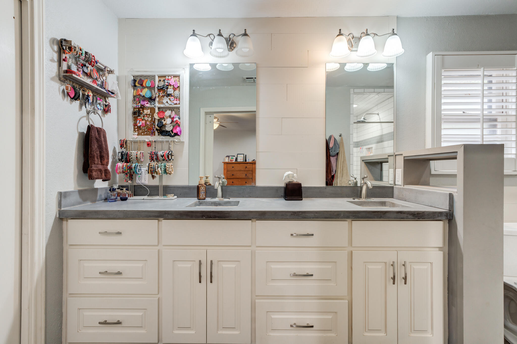 3410 76th Street Lubbock, TX 79423 - Photo 24 of 38 a bathroom with cabinets and chandelier