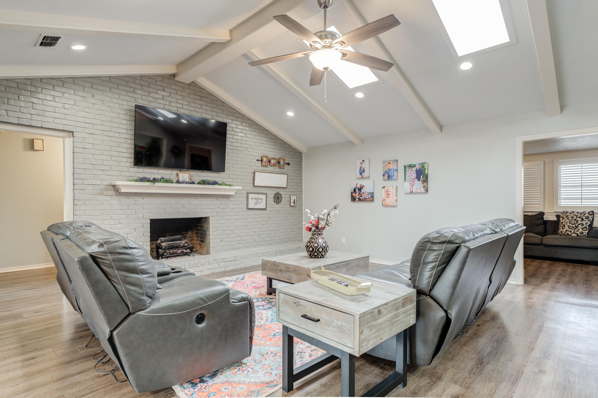 3410 76th Street Lubbock, TX 79423 - Photo 9 of 38 a living room with furniture a fireplace and a flat screen tv